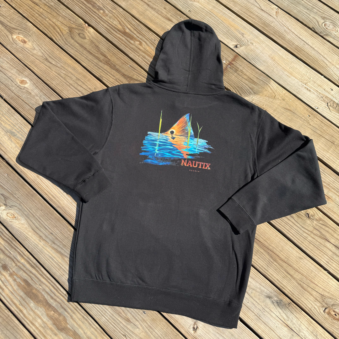 Black hoodie with a sunset graphic and 'Nautix' branding on a wooden surface