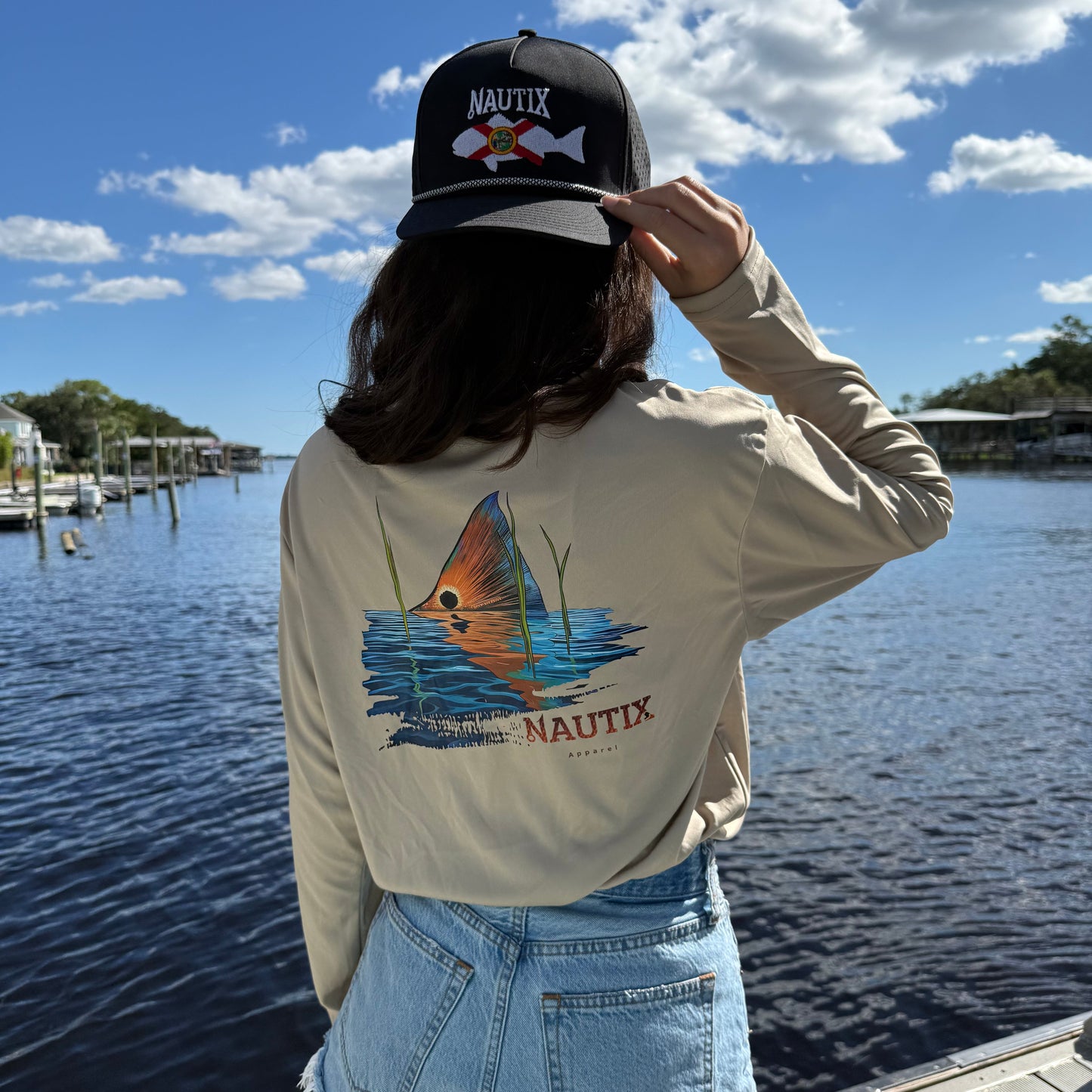 Model wearing sand performance hoodie with large Tailing Red artwork on back