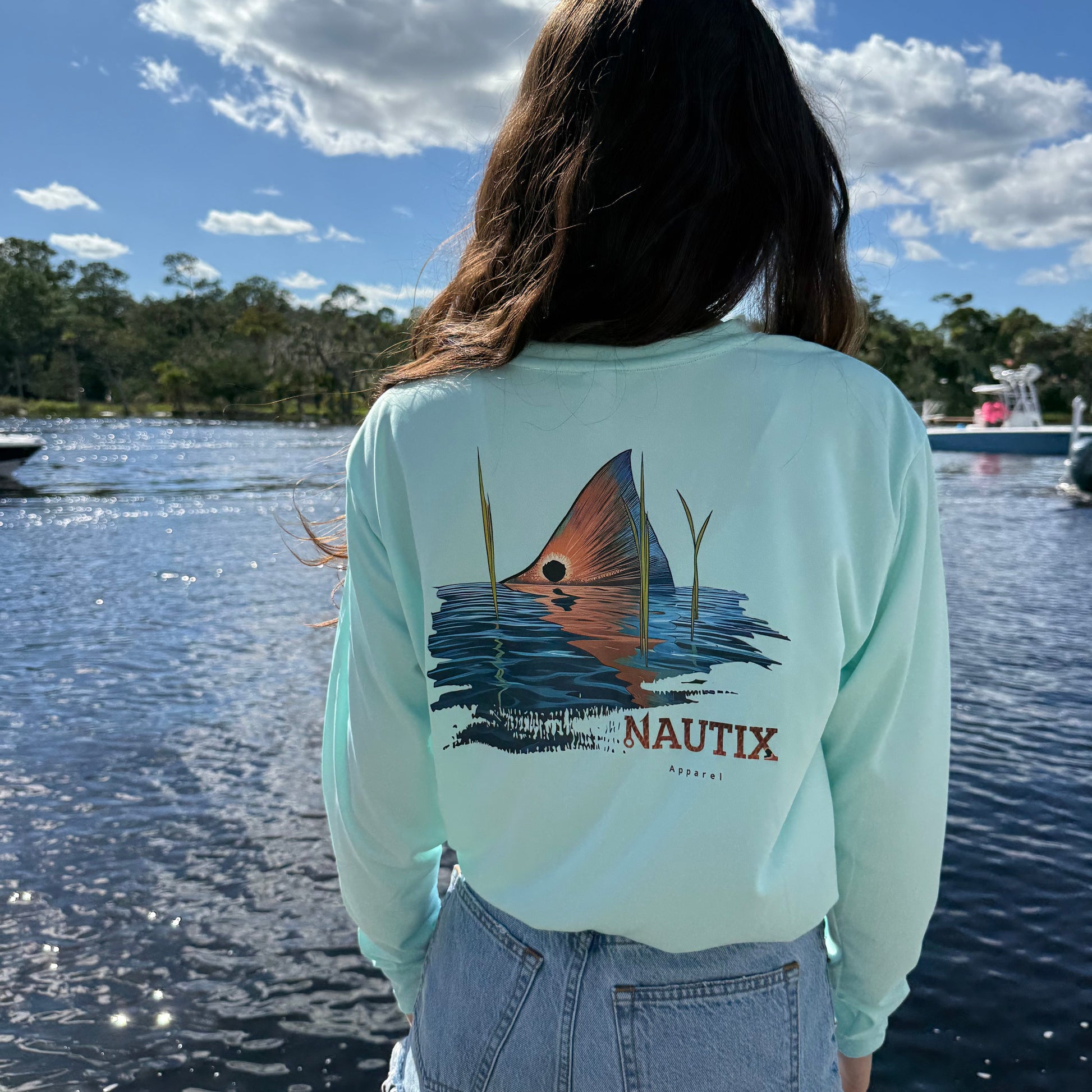 Close-up of Tailing Red redfish scene printed on back of blue performance tee
