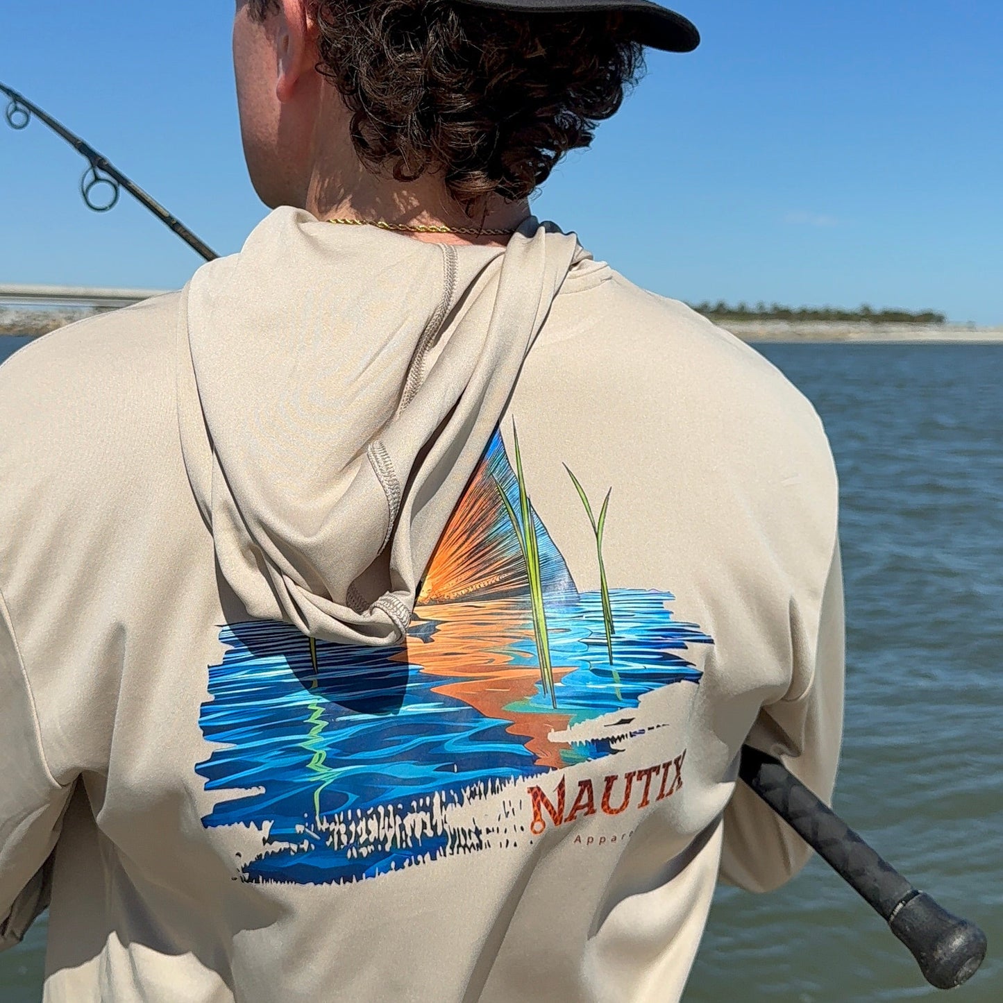 Close-up of Tailing Red redfish scene printed on back of sand performance hoodie