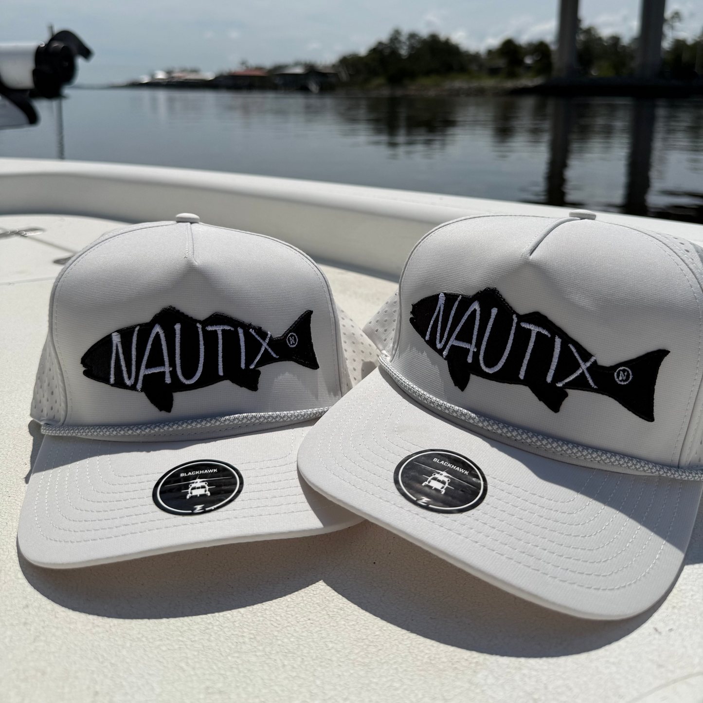 Two Backwater Snapback Hats on a boat with water in the background