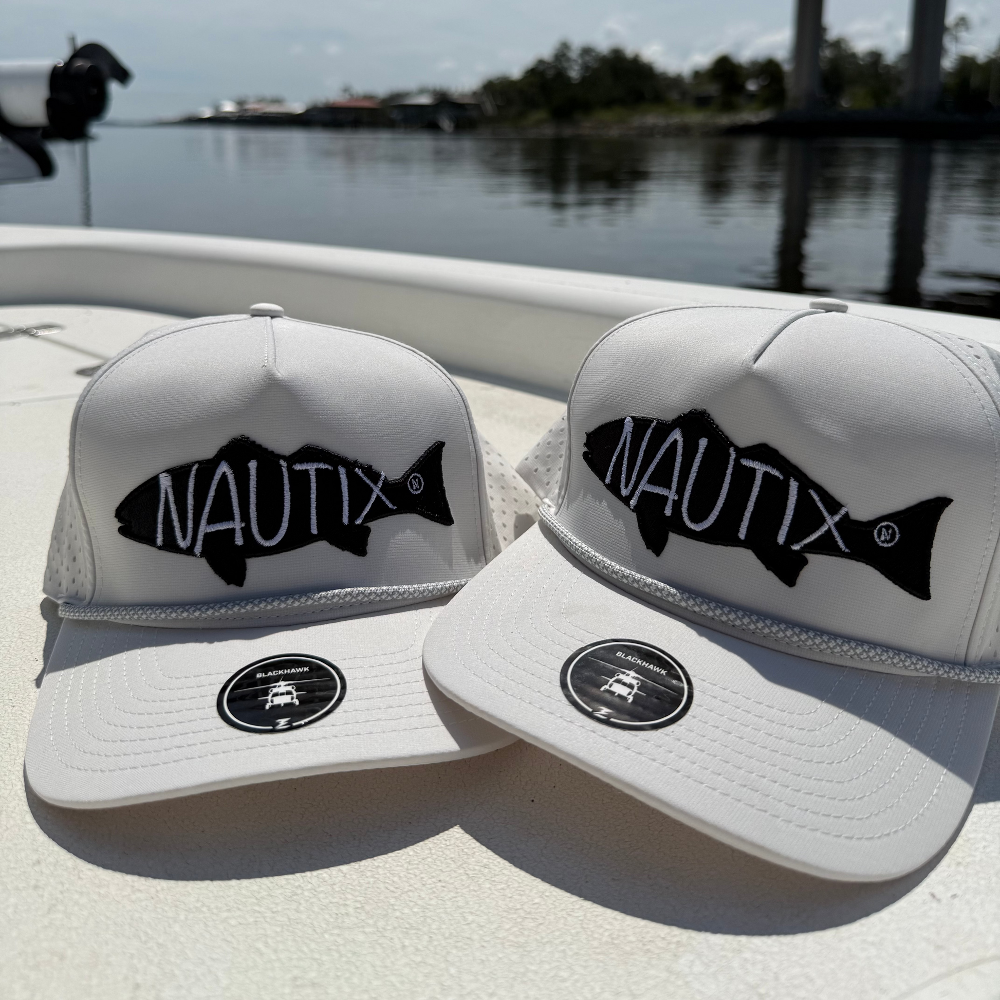 Two Backwater Snapback Hats on a boat with water in the background
